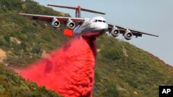 Un avión antincendios BAe-146 lanza químicos sobre las llamas de un incendio en Santa Barbara, California.