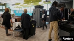 People stand inside a polling station as Georgians turned out a day after the battleground state opened early voting, in Atlanta, Oct. 16, 2024.