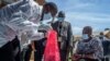 A pharmaceutical expert (L) opens a pack of expired COVID-19 AstraZeneca vaccines to show to Malawi’s Health Minister Khumbize Kandodo Chiponda (R) before they are destroyed in a pharmaceutical incinerator, May 19, 2021. 