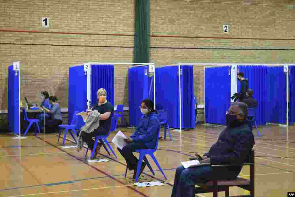 کارڈف، ساؤتھ ویلز میں واقع صحت کے ایک مرکز میں مریض ویکسین وصول کرنے کے لیے ایک دوسرے سے دوری برقرار رکھے ہوئے ہیں۔ 