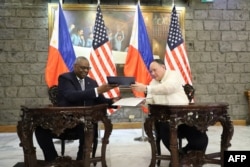 Menteri Pertahanan AS Lloyd Austin dan Menteri Pertahanan Filipina Gilberto Teodoro berpose saat menandatangani General Security of Military Information Agreement (GSOMIA) di Camp Aguinaldo, Quezon City, Metro Manila, pada 18 November. (Foto: via AFP)