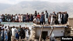 FILE - People search for victims after floods in Charikar, capital of Parwan province, Afghanistan, Aug. 27, 2020.