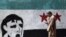 A man walks in front of a wall paint representing Syria revolution, in Cairo