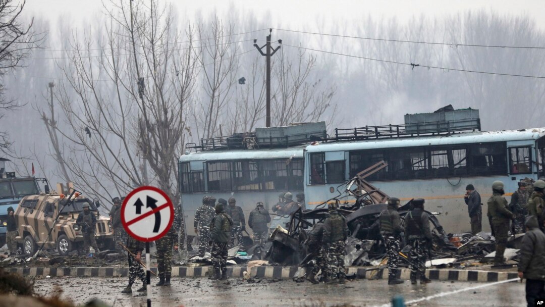 FILE - Indian paramilitary soldiers stand by the wreckage of a bus after an explosion in Pampore, Indian-controlled Kashmir, Thursday, Feb. 14, 2019. 