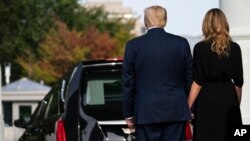 President Donald Trump and first lady Melania Trump watch as the casket of Robert Trump leaves the White House after a memorial service, Aug. 21, 2020, in Washington. 