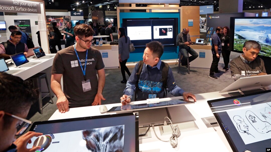 Workers demonstrate Microsoft devices at the Microsoft Build 2017 developers conference in Seattle, May 10, 2017. 