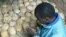 Un survivant prie à côté de crânes des victimes du génocide à Nyamata, Rwanda (avril 2004)