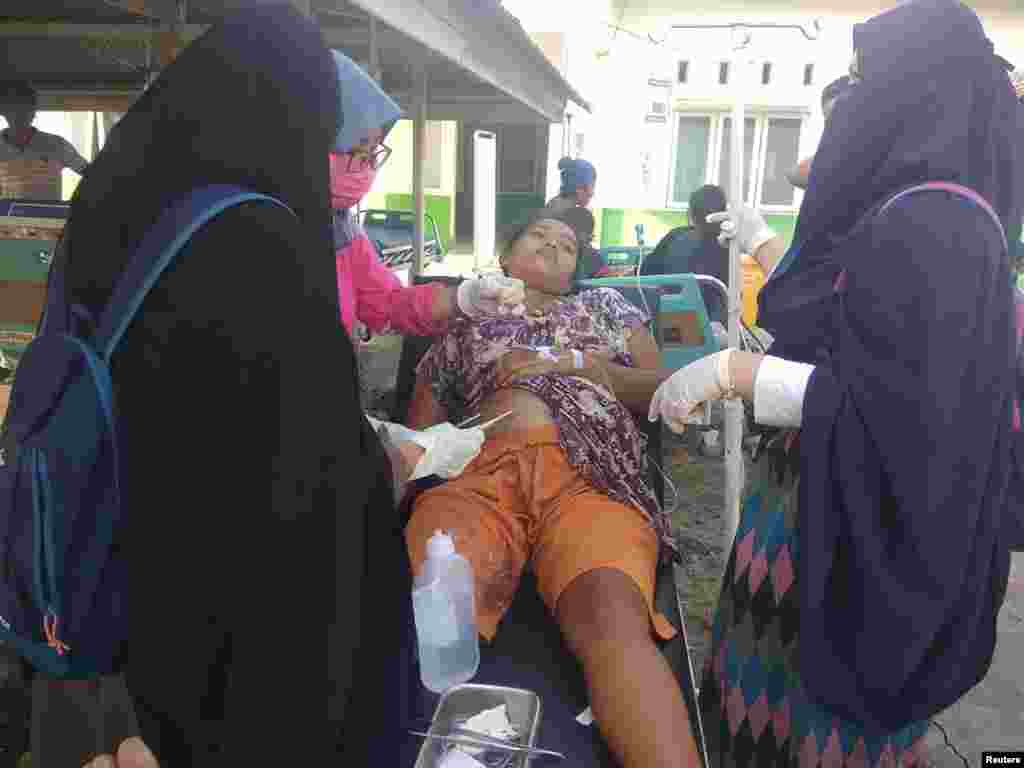 A paramedic gives treatment to an earthquake survivor outside a hospital in Donggala, Indonesia, Sulawesi Island, Sept. 28, 2018.