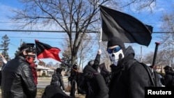 Activistas de antifa enmascarados y vestidos de negro durante una protesta en Michigan el 4 de marzo de 2018.