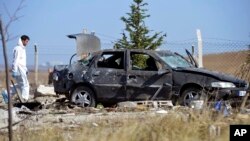 A police forensic officer works at the scene after suicide bombers blew themselves up in Haymana in the outskirts of Ankara, Turkey, Oct. 8, 2016. 