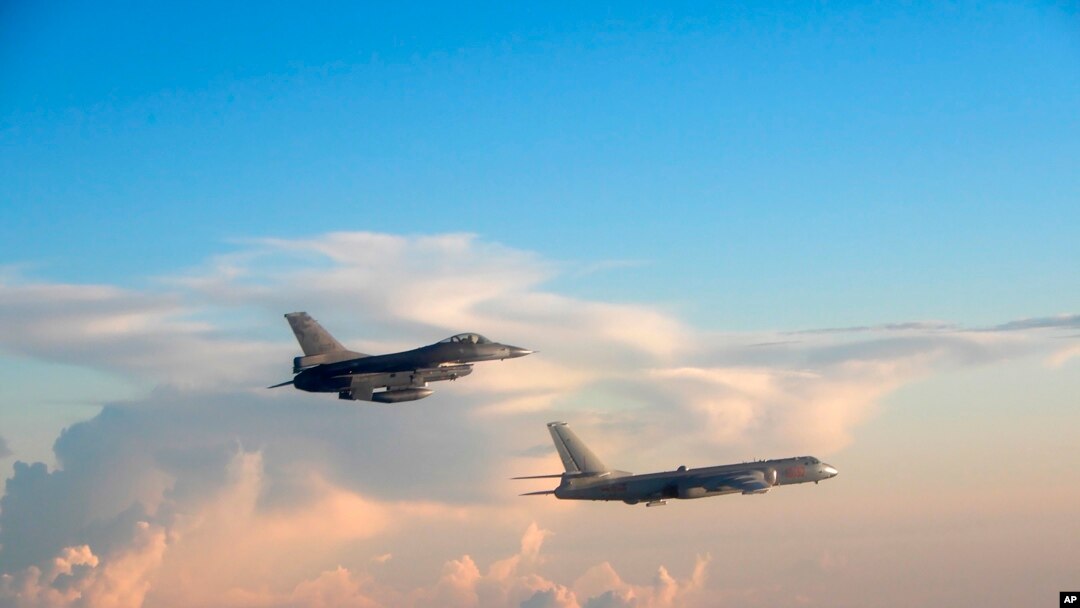 In this file photo taken May 25, 2018, by the Taiwan Ministry of National Defense, a Taiwanese Air Force fighter aircraft, left, flies near a Chinese People's Liberation Army Air Force bomber that reportedly flew over the Luzon Strait south of Taiwan.