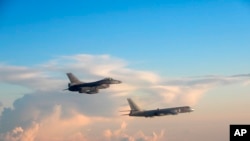 In this file photo taken May 25, 2018, by the Taiwan Ministry of National Defense, a Taiwanese Air Force fighter aircraft, left, flies near a Chinese People's Liberation Army Air Force bomber that reportedly flew over the Luzon Strait south of Taiwan.