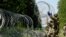 FILE - Lithuanian army soldiers install razor wire on the border with Belarus in Druskininkai, Lithuania, July 9, 2021. 