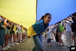 FILE - People take part in a rally marking Ukraine's Independence Day and the six-month anniversary of the Russian invasion of Ukraine in Warsaw, Poland, Wednesday, Aug. 24, 2022. (AP Photo/Michal Dyjuk)