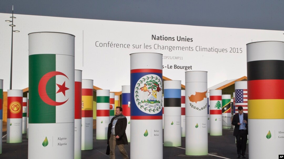 Delegates walk outside the main entrance of the United Nations Climate Change Conference in Le Bourget, outside Paris, Nov. 27, 2015. 