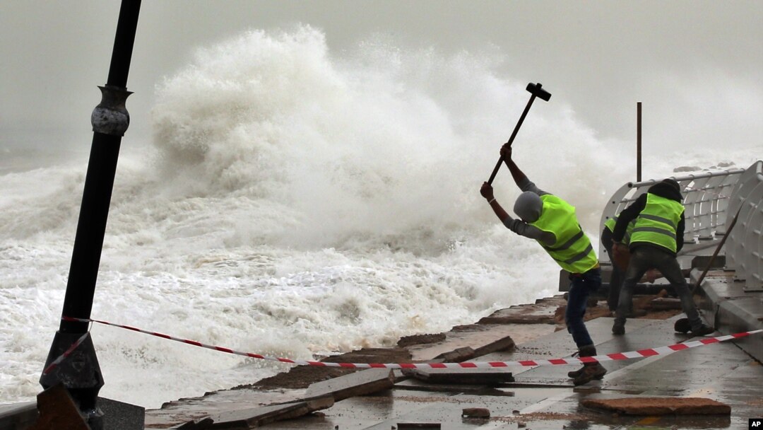 Pekerja memperbaiki pagar pembatas di pinggir pantai yang rusak dihantam ombak di Beirut, Lebanon.