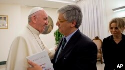 FILE - Pope Francis greets Italian journalist Andrea Tornielli at the Vatican, Jan. 11, 2016.