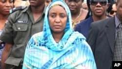 Turai Yar'Adua, wife of late President Umaru Yar'Adua, stands with Patience Jonathan as her husband's body is loaded into a plane to be transported for burial in Katsina.