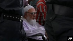 Ghulam Azam, mantan pemimpin Jamaat-e-Islami, partai Islam Bangladesh, dikawal ketat petugas keamanan menuju ruang sidang Mahkamah Kejahatan Perang di Dhaka, Bangladesh (15/7).