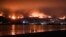 Onlookers are silhouetted against the reflection of a wildfire burning in the Cleveland National Forest in Lake Elsinore, Calif., Aug. 8, 2018. 