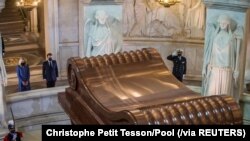 Presiden Perancis Emmanuel Macron dan istrinya, Brigitte Macron berdiri di depan makam Napoleon dalam peringatan 200 tahun kematian Napoleon, di Hotel des Invalides, Paris, Perancis, Rabu, 5 Mei 2021. (Foto: Christophe Petit Tesson/Pool via Reuters) 