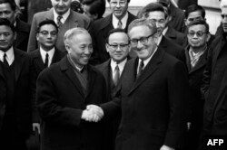FILE - US National Security Advisor Henry Kissinger (R) shakes hand with Le Duc Tho, leader of the North-Vietnam delegation, after the signing of a ceasefire agreement in the Vietnam War in Paris. (Photo by AFP)