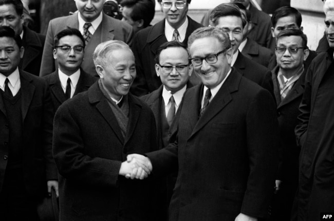 FILE - US National Security Advisor Henry Kissinger (R) shakes hand with Le Duc Tho, leader of the North-Vietnam delegation, after the signing of a ceasefire agreement in the Vietnam War in Paris. (Photo by AFP)