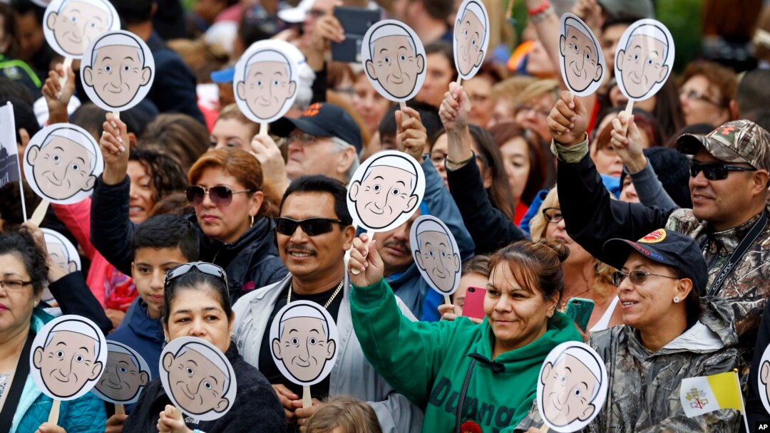 People wave images of Pope Francis as they wait for him to arrive for a Mass at the Cathedral Basilica of Saints Peter and Paul in Philadelphia, Sept. 26, 2015. 