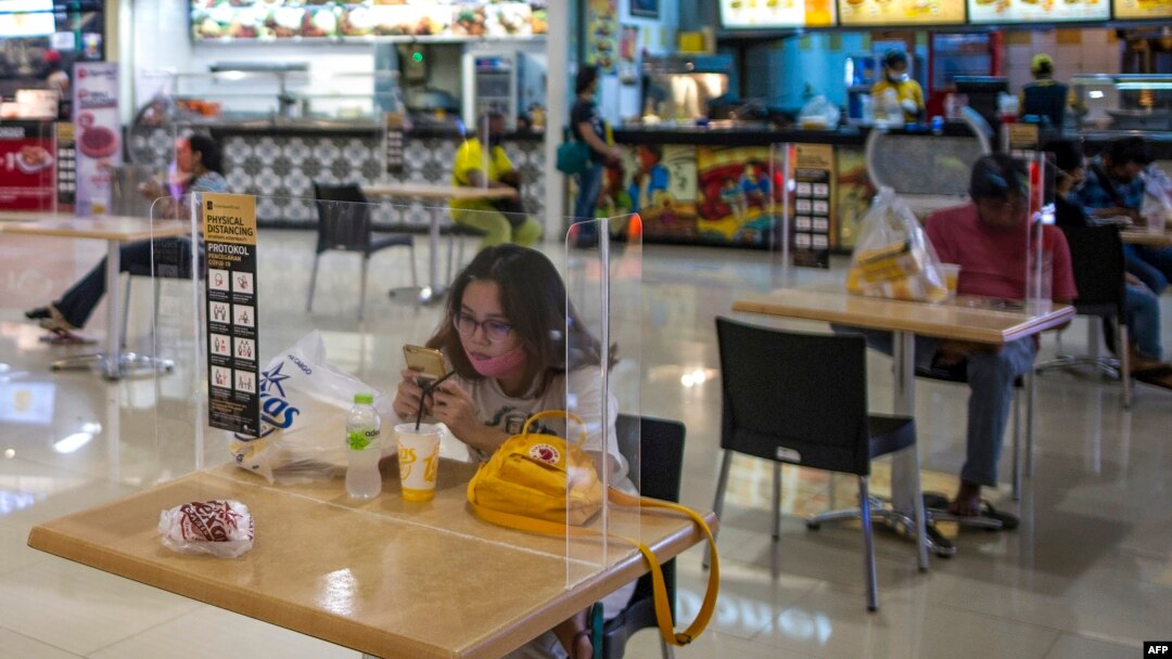 Sebagian pengunjung di sebuah pusat perbelanjaan di Surabaya di tengah pandemi virus corona, 10 Juni 2020. (Foto: AFP)