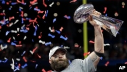 Pemain tim New England Patriots, Julian Edelman, mengangkat piala setelah timnya menjuaarai NFL Superbowl ke-53 melawan Los Angeles Rams, Minggu, 3 Februari 2019 dengan skor 13-3 (foto: AP Photo/David J. Phillip)