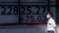 A man walks past an electronic stock board showing Japan's Nikkei 225 index at a securities firm in Tokyo, Aug. 12, 2020. 