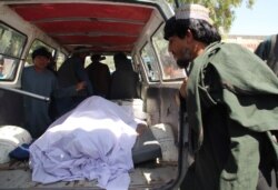 Afghans transport the body of a woman who was killed during a raid by Afghan special forces in the southern Helmand province, Sept. 23, 2019. An Afghan official said at least 40 civilians were killed during the raid and airstrikes against the Taliban.