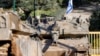 An Israeli army Merkava main battle tank is deployed by the concrete border wall at a position along Israel's northern border with Lebanon on Feb. 18, 2025.