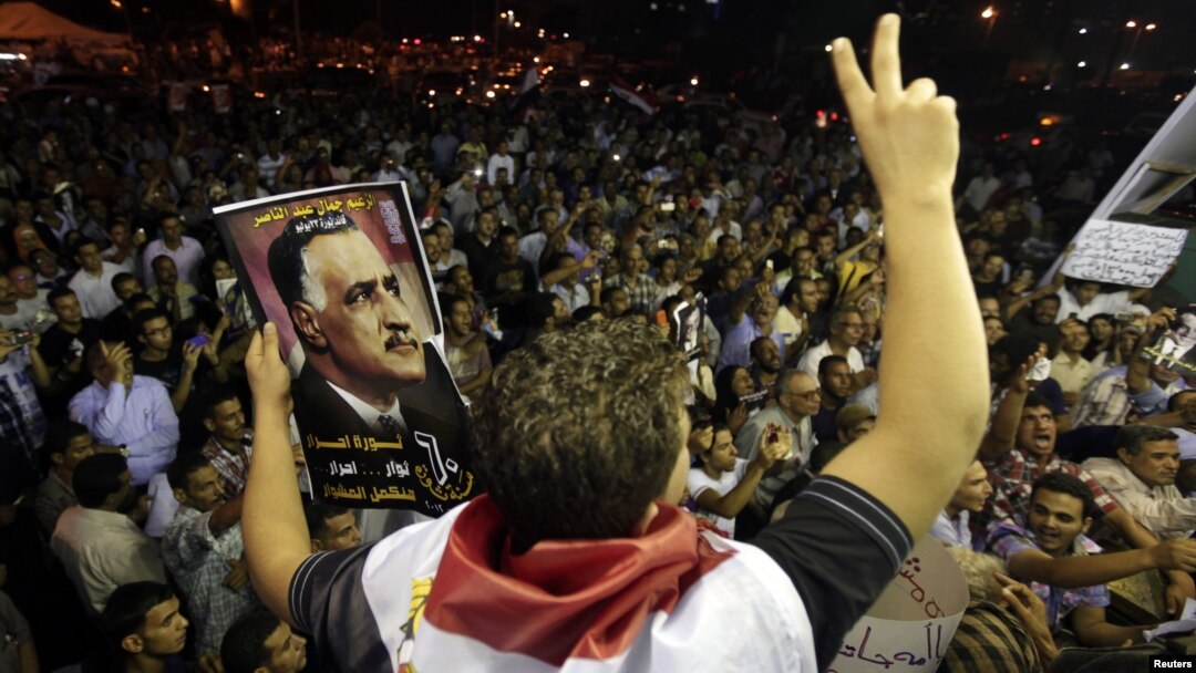 A protester holds up a poster with an image of former Egypt president Gamal Abdel Nasser during the anniversary of the 1952 Egyptian revolution at Tahrir Square in Cairo, July 23, 2012. 