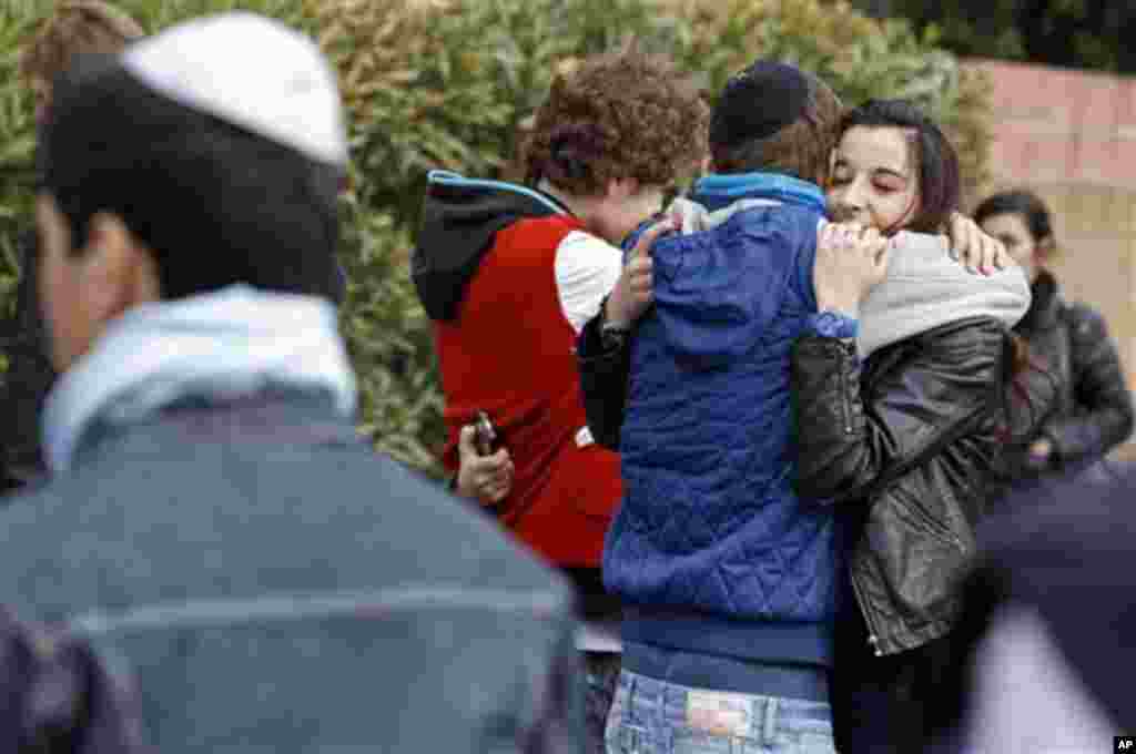 Students comfort each other at the Ozar Hatorah Jewish school where a gunman opened fire killing four people in Toulouse, southwestern France, Monday, March 19, 2012. A father and his two sons were among four people who died Monday when a gunman opened fi