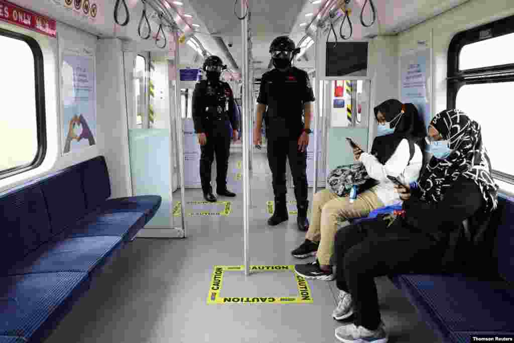 말레이시아 쿠알라룸푸르 기차 안에서 거리를 유지하며 승객의 체온을 젤수 있는 &#39;스마트 헬멧&#39;을 쓴 경찰이 순찰하고 있다. 