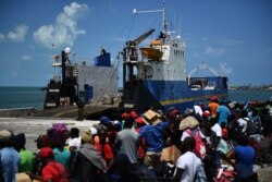 People wait to board a cargo ship for evacuation to Nassau after Hurricane Dorian, Sept. 7, 2019, in Marsh Harbor, Great Abaco. Bahamians who lost everything in Hurricane Dorian were scrambling to escape the worst-hit islands.