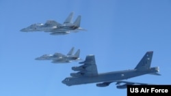 资料照片：美国太平洋空军在X平台公布的照片显示日本自卫队战斗机与一架美国空军B-52H轰炸机2025年12月10日在日本海上空演习。