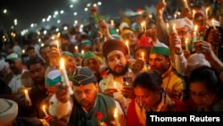 FILE - Farmers take part in a candlelight vigil to honor paramilitary troops killed in a suicide bomb attack in south Kashmir's Pulwama district in 2019, at the site of a protest against new farm laws in Ghaziabad, India, February 14, 2021. REUTERS/Adnan Abidi
