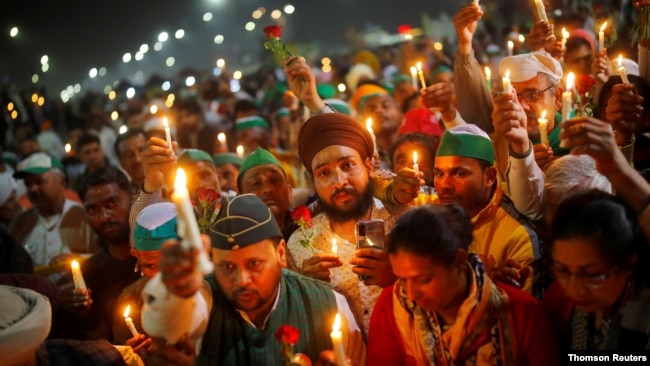 FILE - Farmers take part in a candlelight vigil to honor paramilitary troops killed in a suicide bomb attack in south Kashmir's Pulwama district in 2019, at the site of a protest against new farm laws in Ghaziabad, India, February 14, 2021. REUTERS/Adnan Abidi
