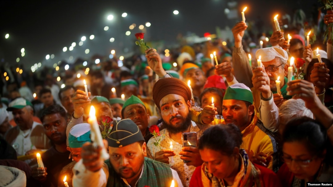 Farmers participate in a candlelight vigil to pay homage to paramilitary troops killed in a suicide bomb attack in south Kashmir's Pulwama district in 2019, in Ghaziabad, India, Feb. 14, 2021.