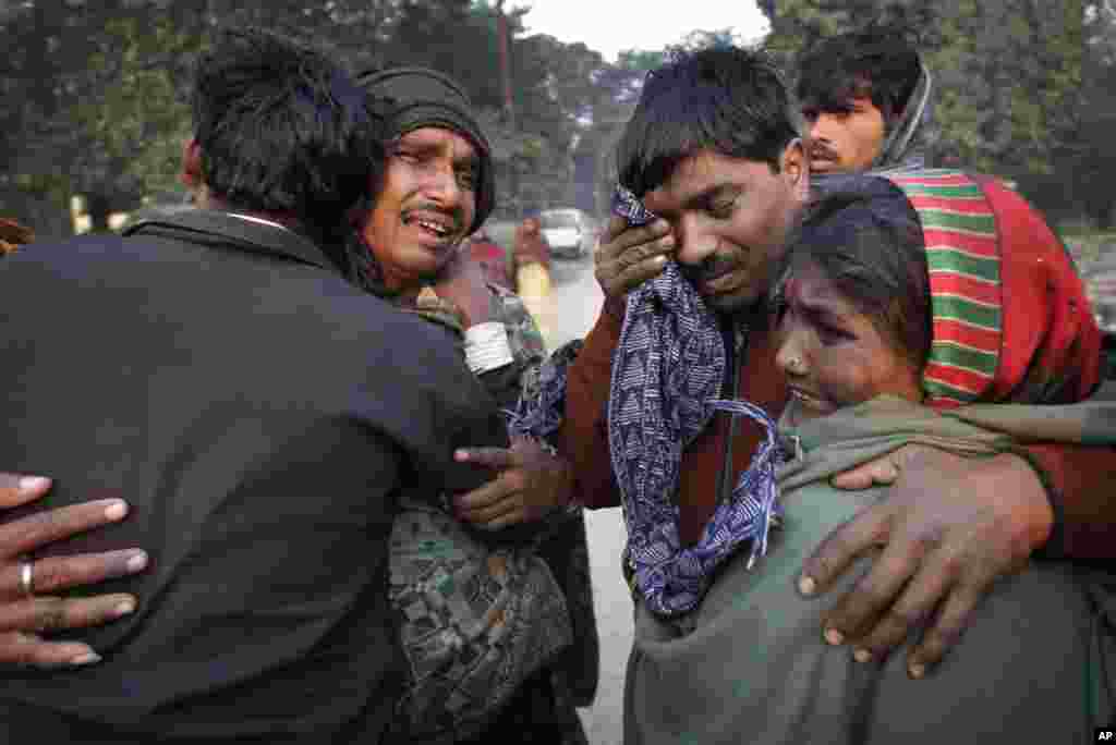 A family whose relative died in a stampede at a railway station cry and comfort each other as they arrive at the morgue, in Allahabad, India, Feb. 11, 2013.