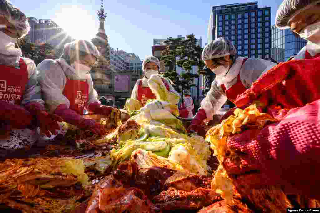 Participants prepare kimchi, a traditional Korean dish of spicy fermented cabbage and radish, during a kimchi making festival at the Jogyesa Buddhist temple in Seoul, South Korea, before it is distributed among the less privileged from the local neighborhood.