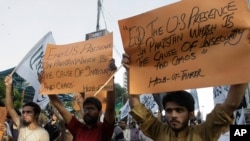 FILE - Activists of Pakistan's banned religious group Hizb-ut-Tahrir hold placards at an anti-U.S. rally in Karachi, Pakistan, April 1, 2012. 