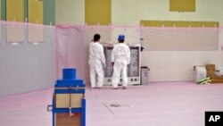 Workers are seen behind local exhauster of the Rest Area of former Emergency Response Measure Room at Tokyo Electric Power Co.'s Fukushima Daiichi Nuclear Power Station in Fukushima prefecture, June 9, 2011 (file photo)