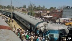 Tim SAR India berupaya menolong korban kecelakaan kereta api di dekat desa Bachhrawan, Uttar Pradesh, India (20/3). (AP Photo/Press Trust of India) 