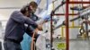 FILE - Employees at Sheffield Platers Inc. work on the factory floor in San Diego, California, Oct. 10, 2013. 