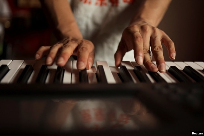 Zu Wenbao, 23, plays keyboard during a practice session with members of the band Star Kids, who like him are all adults with autism spectrum disorder, at a music studio belonging to 38-year-old teacher Chen Shensi, in Beijing, China September 18, 2022. (REUTERS/Tingshu Wang)