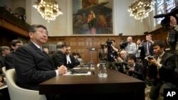 Japanese Ambassador to the Netherlands Koji Tsuruoka, left, waits for the International Court of Justice to deliver its verdict in The Hague, Netherlands, March 31, 2014.