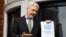 WikiLeaks founder Julian Assange holds a copy of a U.N. ruling as he makes a speech from the balcony of the Ecuadorian Embassy, in central London, Britain, Feb. 5, 2016. 